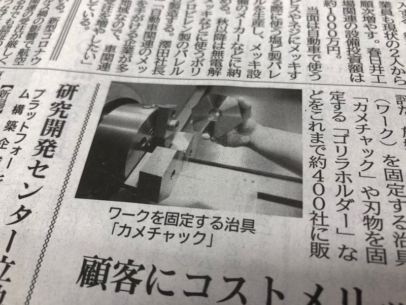 日刊工業新聞に掲載されたNC旋盤に取り付けているカメチャックの写真